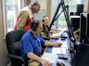 W1AW Station Manager Joe Carcia, NJ1Q (nearest to camera), and ARRL Emergency Preparedness Assistant Manager Ken Bailey, K1FUG (right), working the mics at W1AW, while Red Cross volunteer Rosty Slabicky, W2ROS, looks on. [Michelle Patnode, W3MVP, photo]